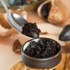 A small clay bowl with black garlic paste on a handmade wooden plate. Spoon with black aioli. Fermented garlic bulb in the background. Healthy and fermented food photo composition, selective focus Pure Silajit from the Himalayas-40g